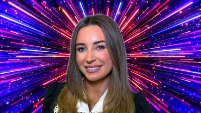 A woman with long hair smiles to camera, set against a sparkling backdrop with beams of blue, pink and purple light