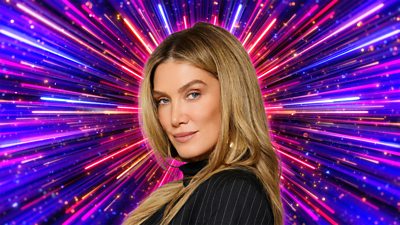 A woman with long blonde hair is pictured side on, looking to camera, set against a background of glittering pink, purple and gold beams of light