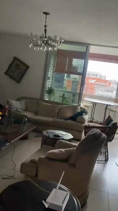 Cell phone video inside a living room filmed at an angle with photo frames and items moved.