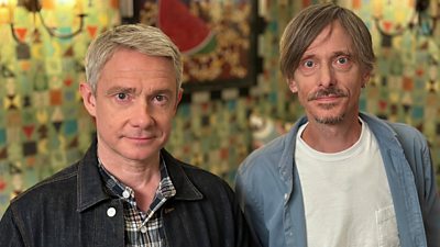 Martin Freeman and Mackenzie Crook stand side-by-side and smile to the camera.