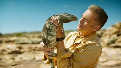 Chris Packham holding a rock monitor lizard in South Africa