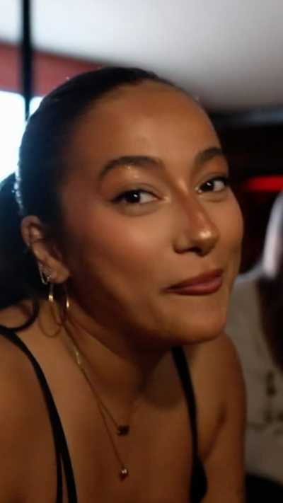 A girl in a black top smiles at the camera.
