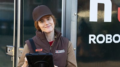 A woman in a delivery uniform holding a tablet. She is wearing a vest that says Cass, and R3botics