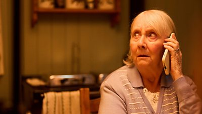 A woman looks worried as she speaks to someone on a mobile phone
