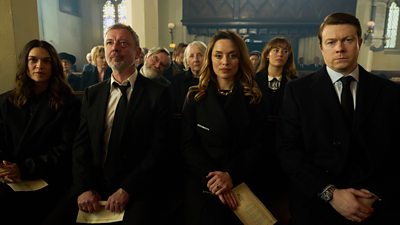 A congregation of peopler gather for a funeral