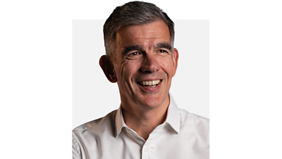 Director General Matt Brittin smiles, looking into the middle distance. He is wearing a white shirt.