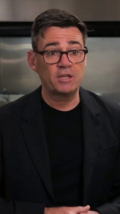 Andy Burnham wearing a black top and jacket
