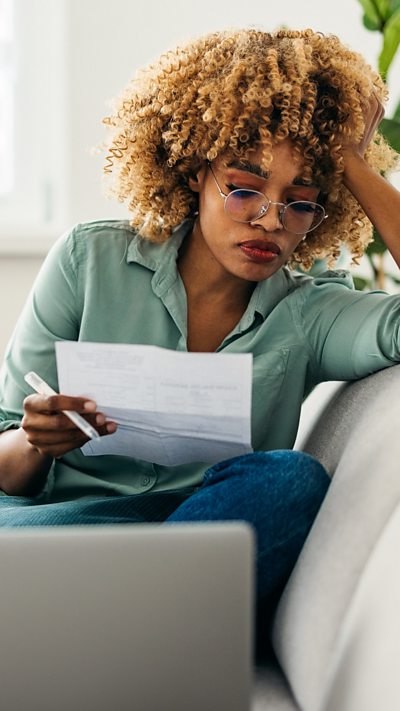 A woman reading a utility bill