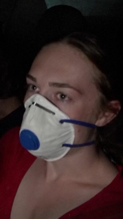 Young woman wears a face mask in her car
