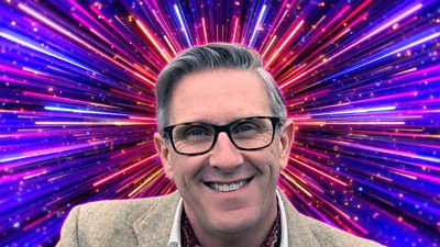 Headshot of Graeme Hall in front of branding for Strictly Come Dancing 2026 - a background of glittering pink, purple and gold beams of light. 