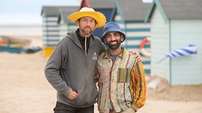 Yusuf Osman (right) with professional Johannes Hogebrink stood on the beach in front of a row of beach huts
