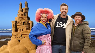 Key art, in the background is the beach and the sea, a sand sculpture of a castle and judges with Sadie Clayton, Iain Stirling and Jamie Wardley