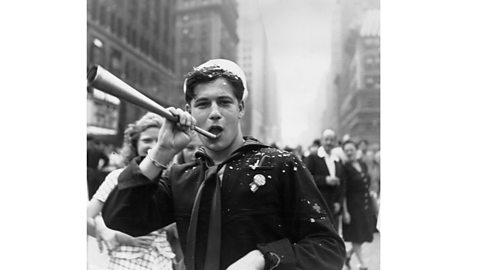 A sailor blows a horn during the VJ Day celebrations in Times Square, New York (1945)