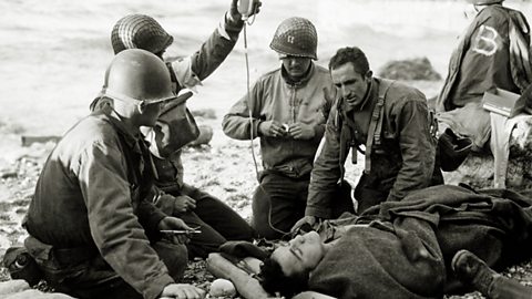A wounded solider being treated by medics. 