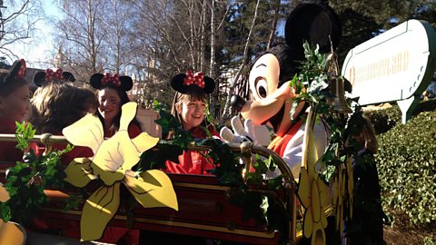A group of girls with Mickey Mouse in Disneyland