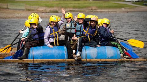 A group of children on a raft on a lake