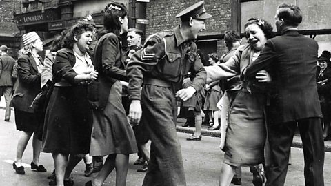 Soldiers and sailors doing the conga through the streets of London