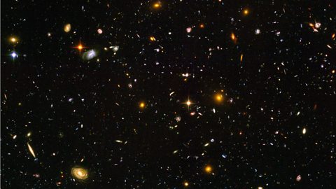 A sea of galaxies floating in space.