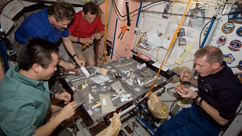 Twenty crewmembers share a meal on the International Space Station.