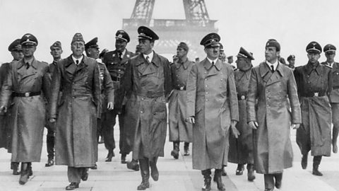 Hitler and other Nazi figures standing in front of the Eiffel Tower in Paris. 