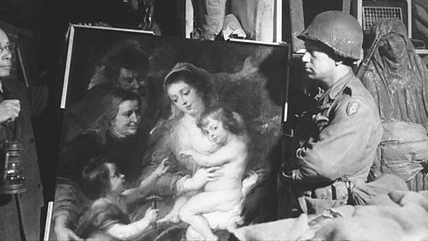 A US soldier inspects priceless art taken from Jews by the Nazis