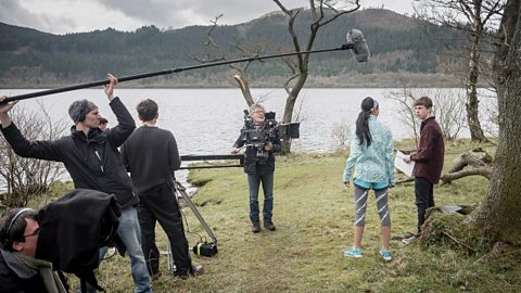 A sound recordist using a boom pole on a film production