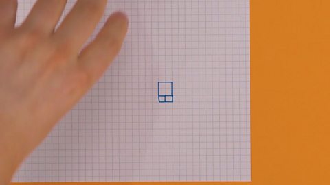 Someone drawing a bigger square on top of two little squares