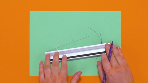 Someone using a ruler to draw a line from the angle to the intersecting curves