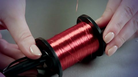 A pen pushed through a spool of copper wire