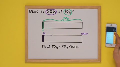 Whiteboard with maths problem and two bars drawn on it and  someone's hand using the calculator on their phone