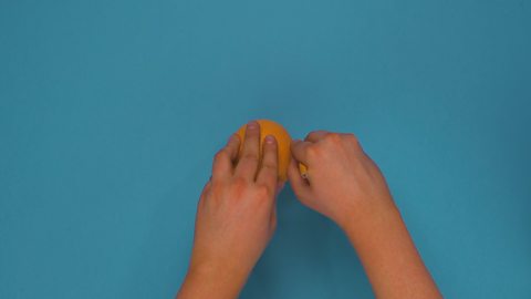 Someone peeling an orange