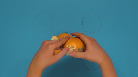 Someone peeling an orange