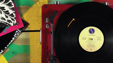 Record on record player with arrow showing rotation