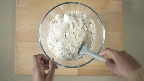 Salt, sugar and yeast being mixed in with the flour