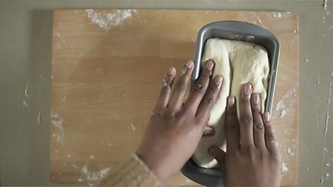 The dough being put into the bread tin