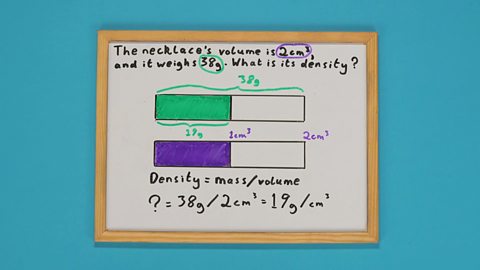 A whiteboard with two shaded bars drawn on it and a maths problem underneath it