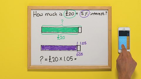 A whiteboard with two shaded bars on it, a maths sum underneath and someone using their calculator