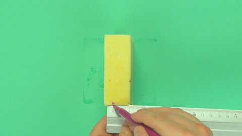 Someone marking their measurements on a block of cheese