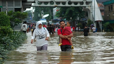 A family wading through flood waters