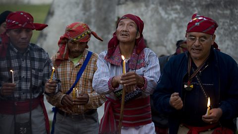 Four Maya men holding candles