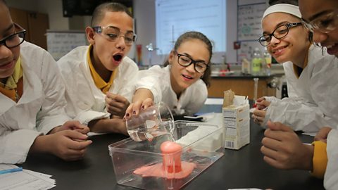 Students react to a vinegar and baking soda volcano in class