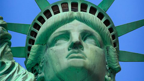 Close up of the Statue of Liberty's head and shoulders with green discolouration visible on its copper surface