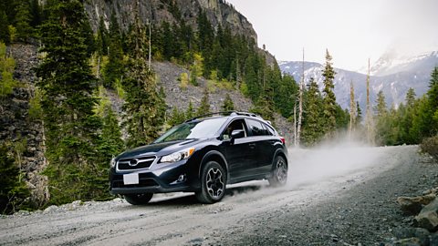 Car driving down dusty gravel road
