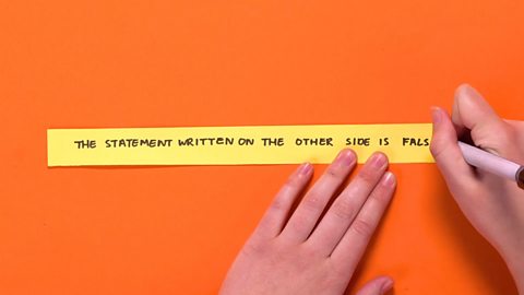 A strip of paper being written on.