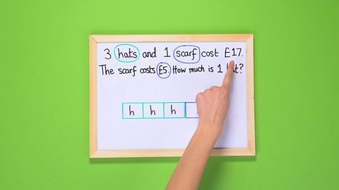 A maths problem being written on a mini whiteboard