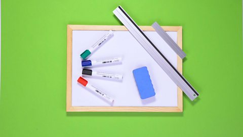 A whiteboard, a ruler, an eraser and some marker pens