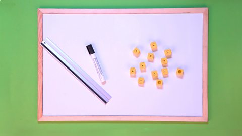 A whiteboard, marker, ruler and cubes (or whatever items you have to hand).