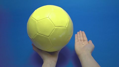 Comparing the size of a football and small ball of modelling clay.