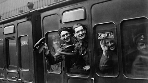 World War One soldiers waving through a train carriage window