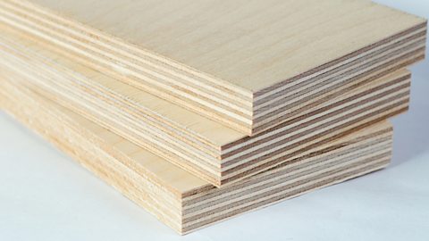 A stack of three pieces of light plywood boards.